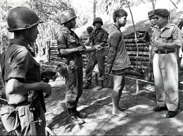 South Vietnamese troops interrogate a suspected Viet Cong during 1962. Note that they have removed the buttstocks from their M1A1 Thompson guns to save weight, a common practice among South Vietnamese troops.