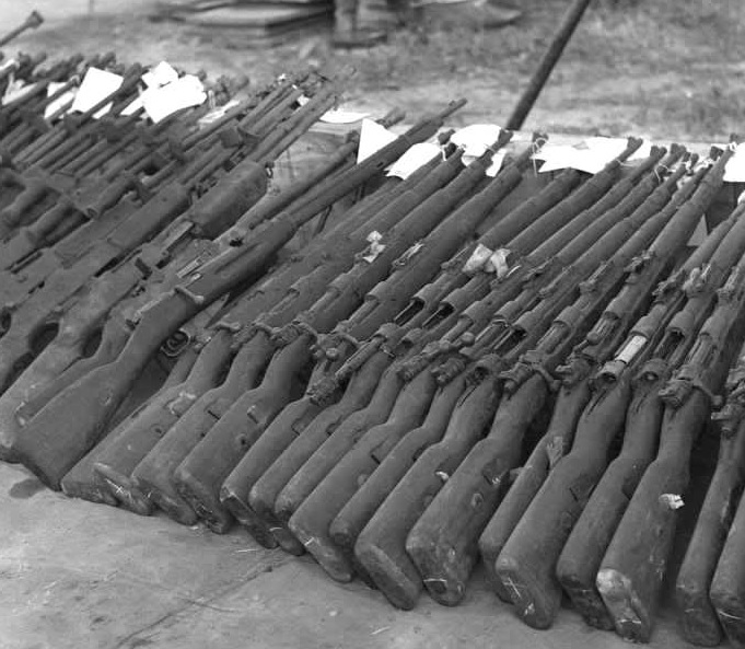 A spread of WWII-era firearms captured from the Việt Cộng by the US Army in the 1960s. No fewer than seventeen 98k rifles are visible, along with a Mosin–Nagant, several Brens, and a PTRD-1941.