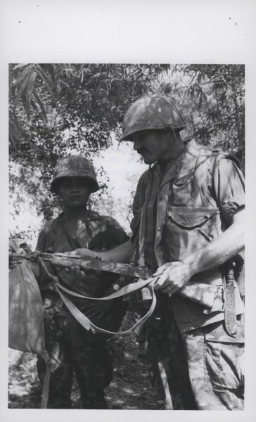 War Prize: Staff Sergeant William T. Turner, 33 (Shreveport, Louisiana) and a Vietnamese interpreter examine a captured AK-47 assault rifle found by E Company, 2d Battalion, 5th Marines (official USMC photo by Private A.