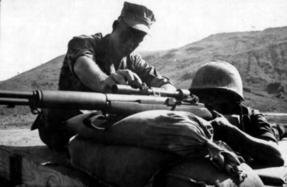 A USMC instructor shows an ARVN soldier how to operate the M1D rifle at the Dai La Pass range in November 1969.